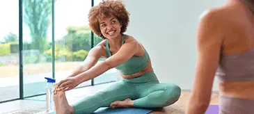 Woman taking Mounjaro weight loss treatment exercising on a yoga mat